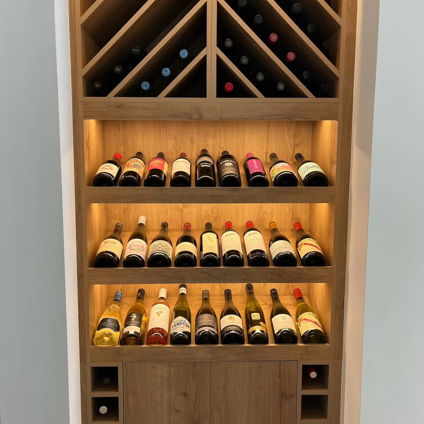 Illuminated wine display cabinet with custom timber shelving